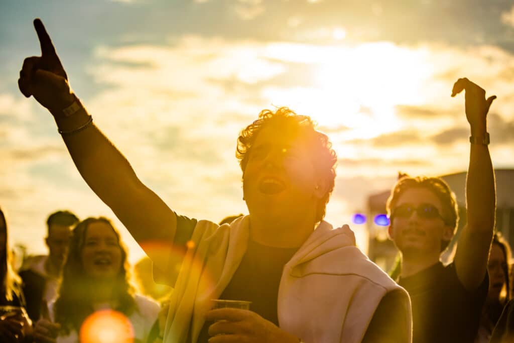Feestend publiek in de ondergaande zon